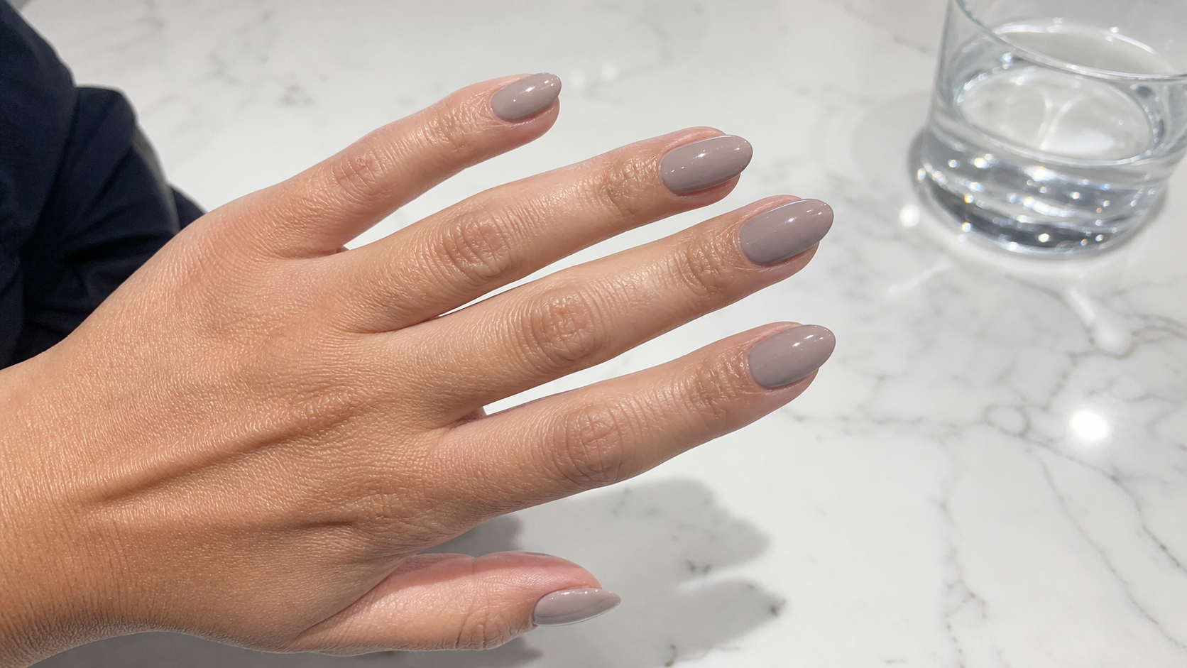 Manicure minimalista en tonos piedra con un acento abstracto